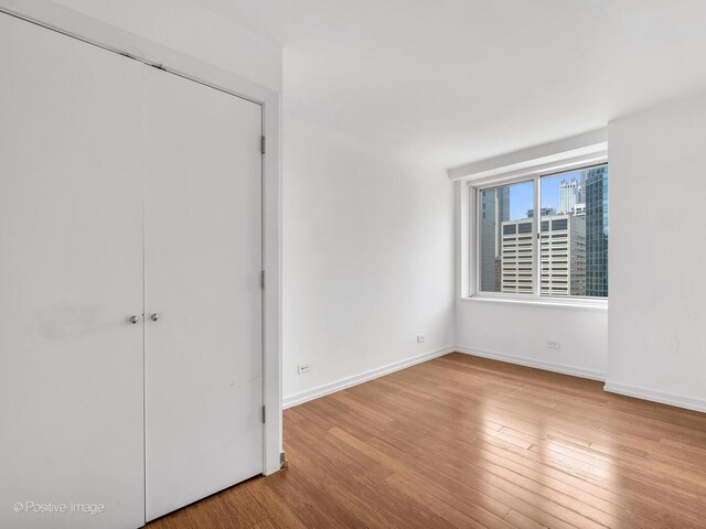 211 E Ohio St Unit 2707, Chicago, IL 60611 - unfurnished bedroom with wood finished floors and a closet