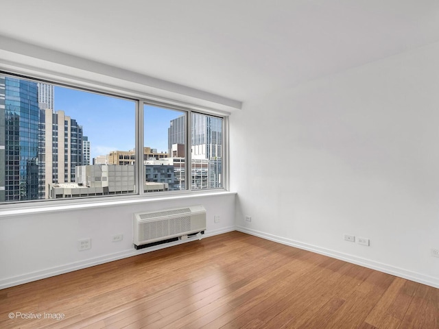 211 E Ohio St Unit 2707, Chicago, IL 60611 - spare room with an AC wall unit, wood finished floors, and a city view