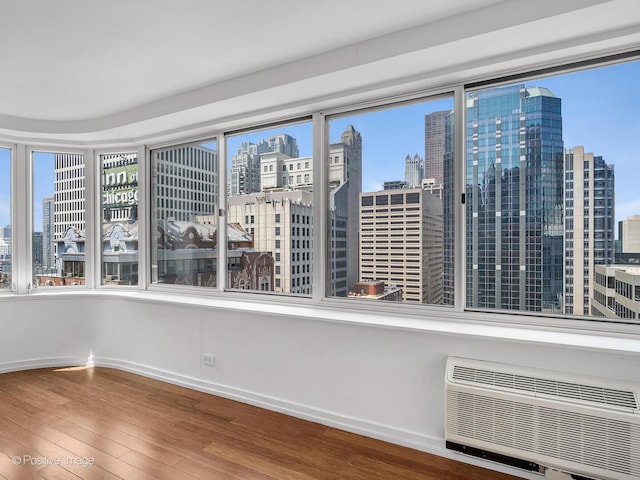 211 E Ohio St Unit 2707, Chicago, IL 60611 - empty room with a view of skyline, wood finished floors, and a wall mounted air conditioner
