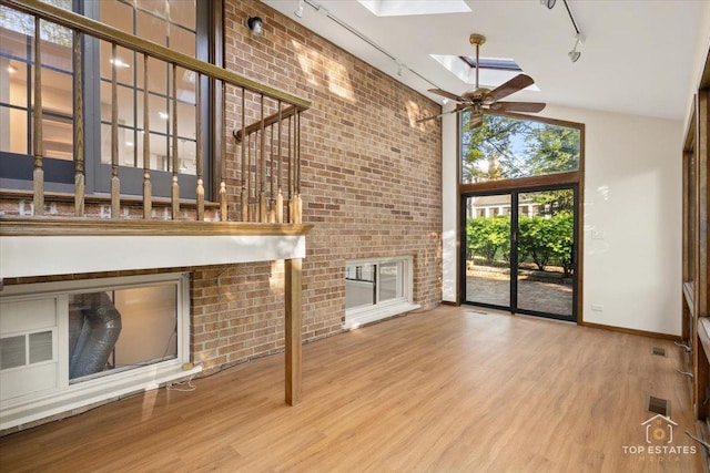 21824 Cambridge Dr, Kildeer, IL 60047 - unfurnished living room featuring track lighting, a towering ceiling, a skylight, wood finished floors, and ceiling fan