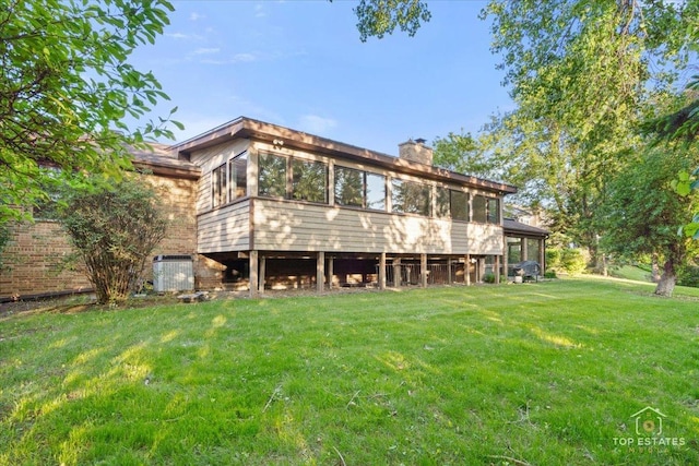 21824 Cambridge Dr, Kildeer, IL 60047 - rear view of property with a sunroom, a yard, and a chimney