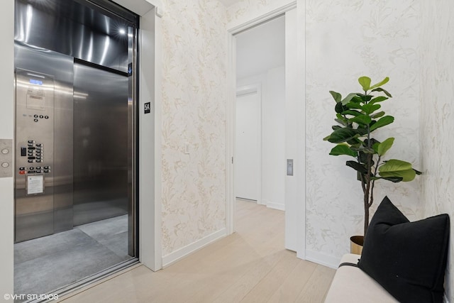 128 S Green St Unit 5Ab, Chicago, IL 60607 - hallway with wallpapered walls, elevator, and light wood-type flooring