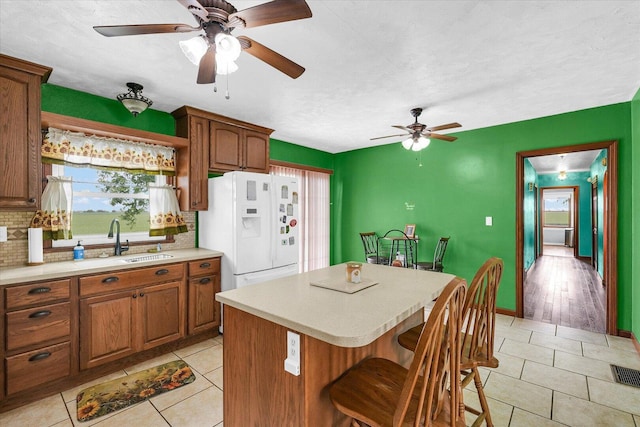 9101 US Highway 36, Metcalf, IL 61940 - kitchen with white refrigerator with ice dispenser, a ceiling fan, light countertops, backsplash, and light tile patterned floors