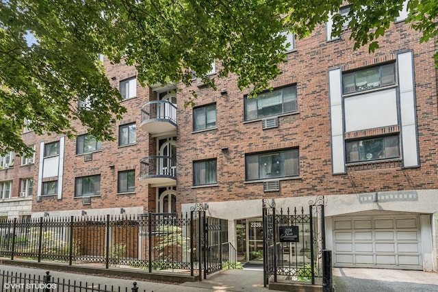 2336 N Commonwealth Ave Unit 108, Chicago, IL 60614 - view of apartment building / complex featuring a fenced front yard and an attached garage
