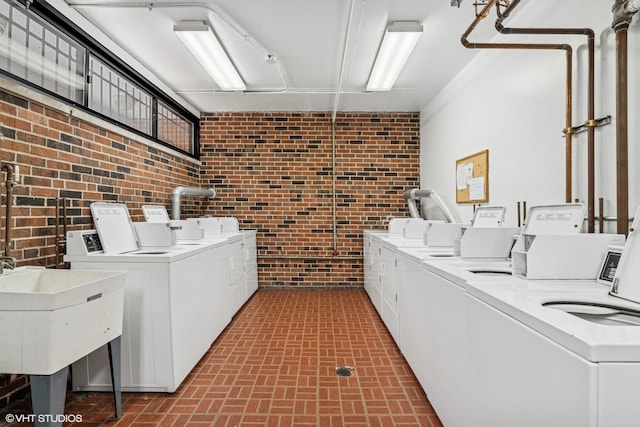 2336 N Commonwealth Ave Unit 108, Chicago, IL 60614 - shared laundry featuring washer and dryer, brick wall, and brick patterned floors