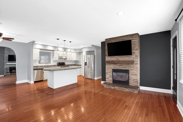 717 Bittersweet Ln, New Lenox, IL 60451 - kitchen featuring a stone fireplace, stainless steel appliances, open floor plan, white cabinetry, and recessed lighting