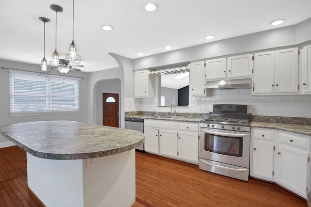717 Bittersweet Ln, New Lenox, IL 60451 - kitchen featuring appliances with stainless steel finishes, under cabinet range hood, dark wood-style floors, decorative backsplash, and white cabinetry