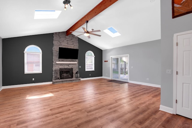 717 Bittersweet Ln, New Lenox, IL 60451 - unfurnished living room featuring a skylight, a ceiling fan, a fireplace, and wood finished floors