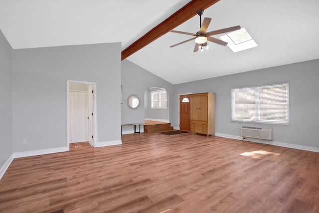 717 Bittersweet Ln, New Lenox, IL 60451 - unfurnished living room featuring ceiling fan, an AC wall unit, a skylight, beam ceiling, and light wood-type flooring