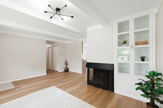 3616 Tamarind Ln, Hazel Crest, IL 60429 - unfurnished living room featuring light wood-style flooring, a multi sided fireplace, and a chandelier