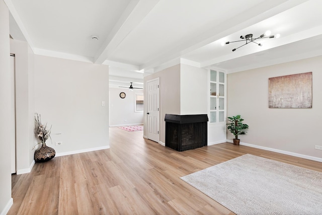 3616 Tamarind Ln, Hazel Crest, IL 60429 - unfurnished living room with a chandelier, light wood-style floors, a multi sided fireplace, beamed ceiling, and ceiling fan