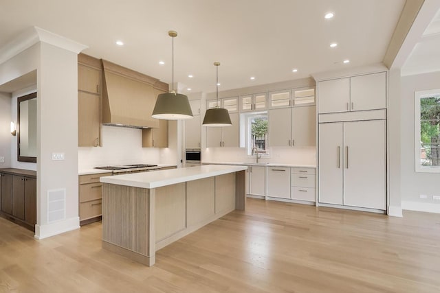 1437 Ashland Ave, River Forest, IL 60305 - kitchen featuring custom exhaust hood, light wood-type flooring, light countertops, decorative backsplash, and a kitchen island
