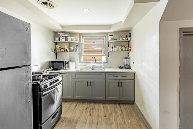 4636 S Keating Ave, Chicago, IL 60632 - kitchen featuring appliances with stainless steel finishes, open shelves, gray cabinetry, light wood-type flooring, and light countertops