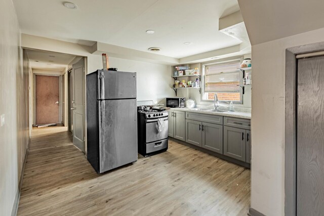 4636 S Keating Ave, Chicago, IL 60632 - kitchen featuring appliances with stainless steel finishes, gray cabinets, light wood-style flooring, open shelves, and light countertops