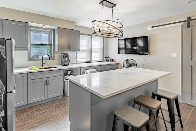 4636 S Keating Ave, Chicago, IL 60632 - kitchen featuring gray cabinetry, freestanding refrigerator, wood finished floors, and a barn door