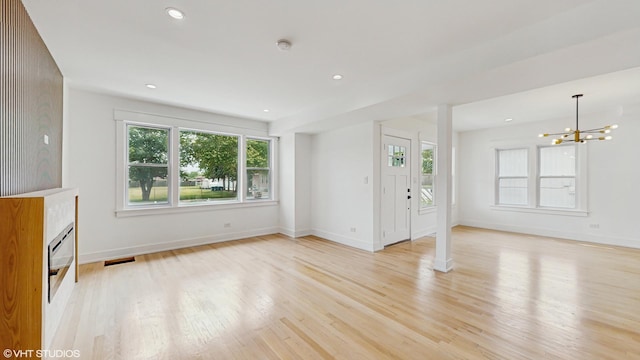 15230 State St, South Holland, IL 60473 - unfurnished living room with light wood-style floors, a chandelier, a fireplace, and recessed lighting