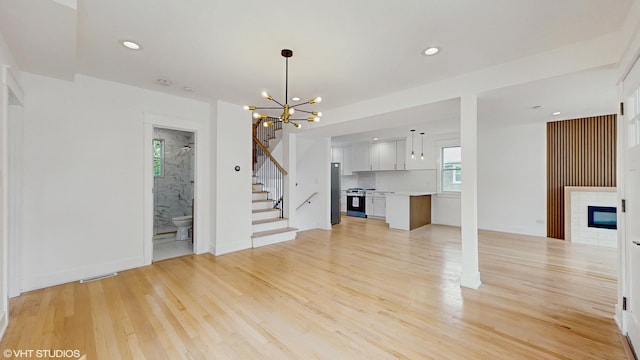 15230 State St, South Holland, IL 60473 - unfurnished living room featuring stairs, a chandelier, light wood-type flooring, a fireplace, and recessed lighting