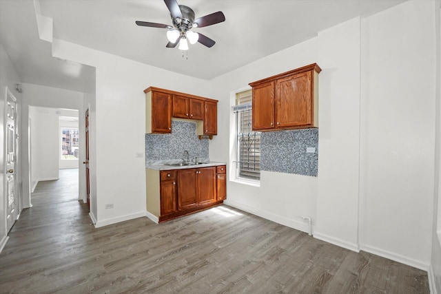 1318 S Kolin Ave, Chicago, IL 60623 - kitchen featuring ceiling fan, wood finished floors, tasteful backsplash, light countertops, and brown cabinetry