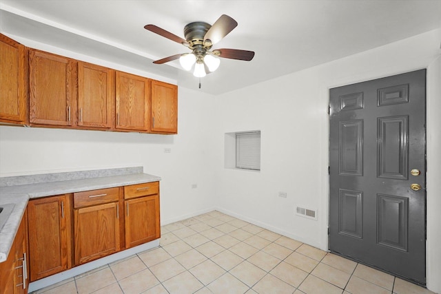 1318 S Kolin Ave, Chicago, IL 60623 - kitchen featuring brown cabinets, light countertops, a ceiling fan, and light tile patterned flooring