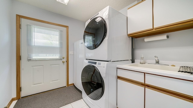 70 Delburne Dr, Davis, IL 61019 - laundry room with stacked washer / dryer, cabinet space, and tile patterned floors