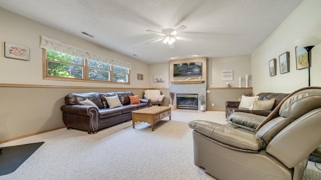 70 Delburne Dr, Davis, IL 61019 - carpeted living room with ceiling fan, a glass covered fireplace, and a textured ceiling