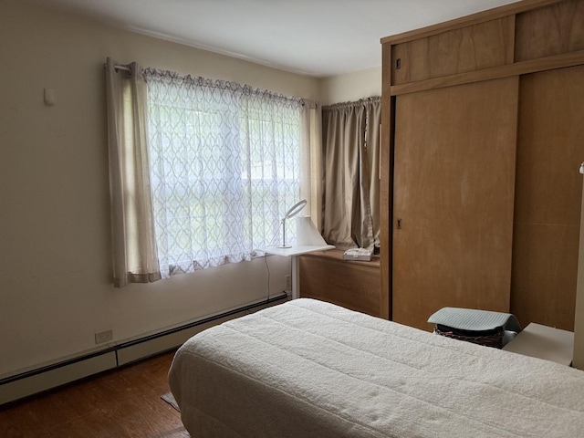 616 E Prairie Ave, Des Plaines, IL 60016 - bedroom featuring a baseboard radiator, a closet, and dark wood-style flooring