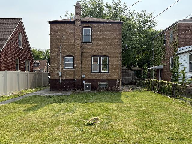 10750 S Ridgeway Ave, Chicago, IL 60655 - rear view of property featuring a chimney, a fenced backyard, and brick siding