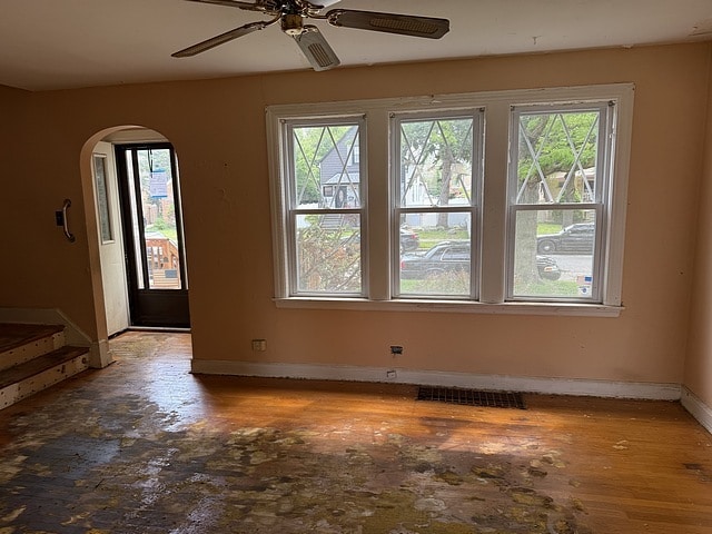 10750 S Ridgeway Ave, Chicago, IL 60655 - empty room with healthy amount of natural light, arched walkways, ceiling fan, and wood finished floors