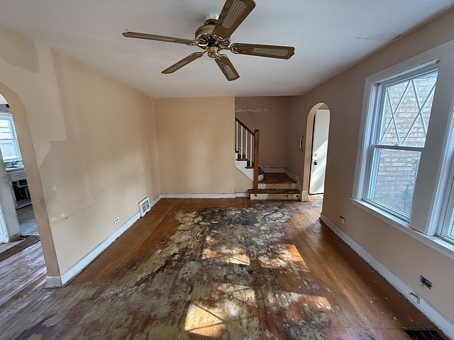 10750 S Ridgeway Ave, Chicago, IL 60655 - spare room with arched walkways, wood finished floors, a ceiling fan, and stairs