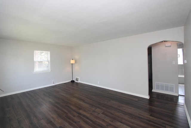 1001 Wilcox St, Joliet, IL 60435 - spare room featuring arched walkways, dark wood-style flooring, and plenty of natural light