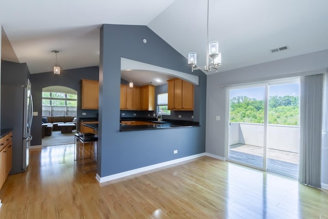 2746 Acorn Ct Unit 2746, West Dundee, IL 60118 - kitchen featuring freestanding refrigerator, vaulted ceiling, arched walkways, light wood finished floors, and dark countertops