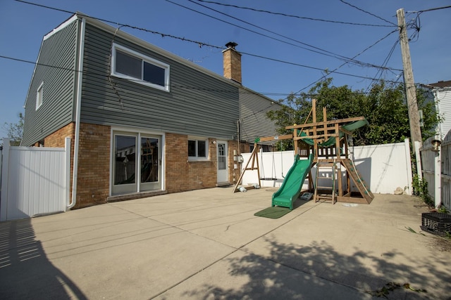 9135 Hollyberry Ave, Des Plaines, IL 60016 - back of house featuring brick siding, a playground, a chimney, and a patio area