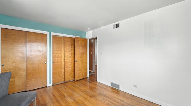 139 Hyde Park Ave, Bellwood, IL 60104 - unfurnished bedroom with two closets and wood finished floors