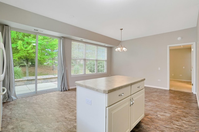 11837 Messiner Dr, Huntley, IL 60142 - kitchen featuring a kitchen island, light countertops, pendant lighting, a chandelier, and white cabinetry