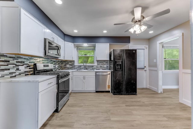 22904 Valley Dr, Richton Park, IL 60471 - kitchen featuring appliances with stainless steel finishes, white cabinetry, tasteful backsplash, light wood-style floors, and ceiling fan