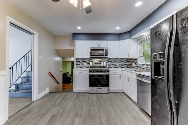 22904 Valley Dr, Richton Park, IL 60471 - kitchen featuring stainless steel appliances, light wood finished floors, decorative backsplash, white cabinets, and a ceiling fan