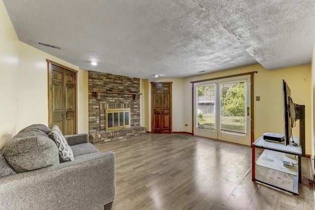 22904 Valley Dr, Richton Park, IL 60471 - living room with a textured ceiling, wood finished floors, and a brick fireplace