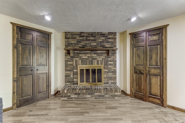 22904 Valley Dr, Richton Park, IL 60471 - unfurnished living room featuring a textured ceiling, light wood-type flooring, a fireplace, and recessed lighting