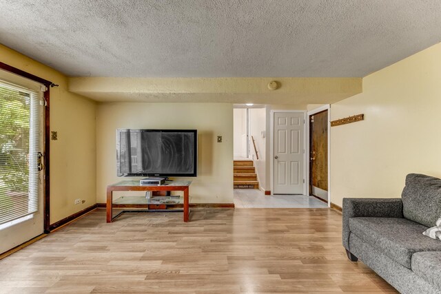 22904 Valley Dr, Richton Park, IL 60471 - living room with a textured ceiling, light wood-style flooring, and stairs