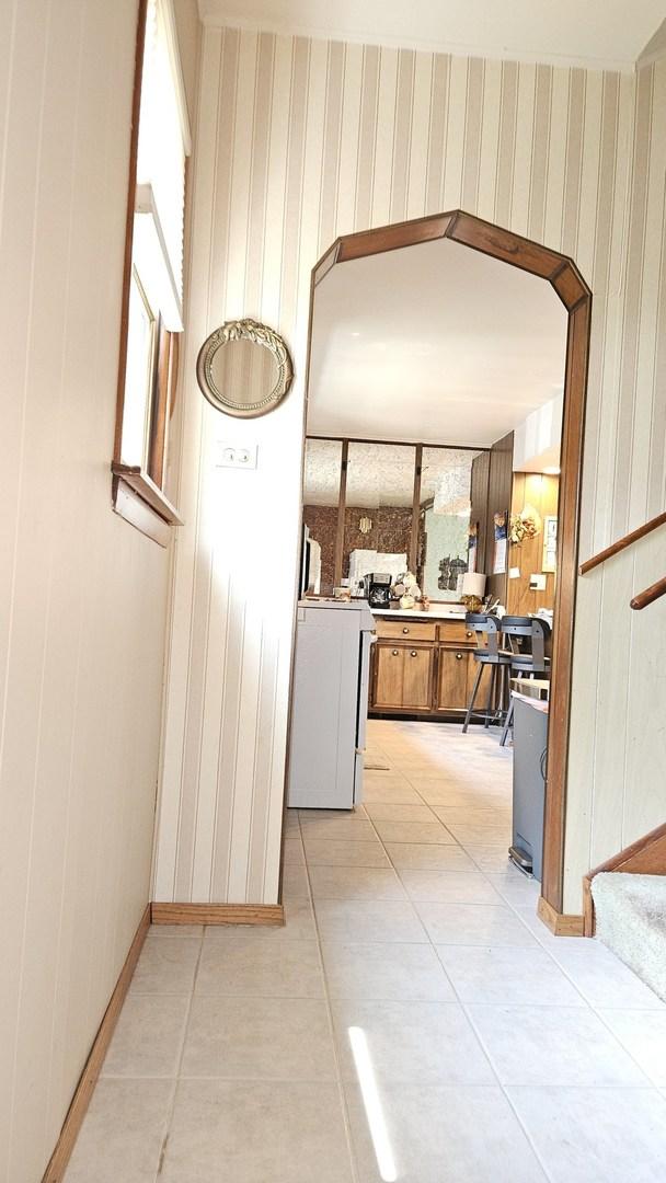14357 Kenton Ave, Midlothian, IL 60445 - hall with light tile patterned floors and wooden walls