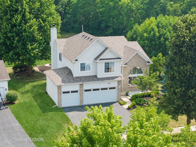 134 S Hankes Rd, Aurora, IL 60506 - view of front facade with asphalt driveway, brick siding, a garage, and a chimney