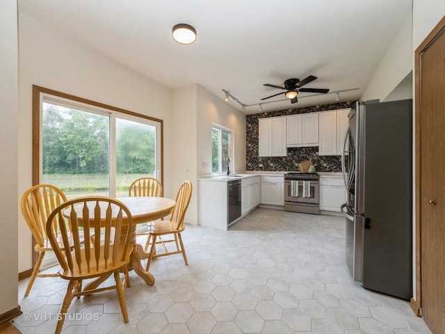 134 S Hankes Rd, Aurora, IL 60506 - kitchen with appliances with stainless steel finishes, rail lighting, white cabinetry, a ceiling fan, and tasteful backsplash