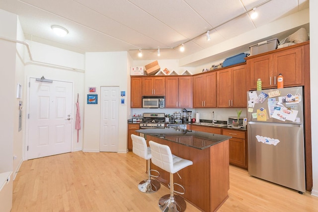 1919 S Michigan Ave Unit 412, Chicago, IL 60616 - kitchen featuring stainless steel appliances, rail lighting, brown cabinets, and light wood-type flooring