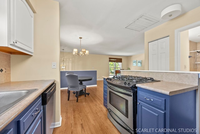 1006 Britta Ln, Geneva, IL 60134 - kitchen featuring appliances with stainless steel finishes, blue cabinets, white cabinets, light wood-style floors, and tasteful backsplash