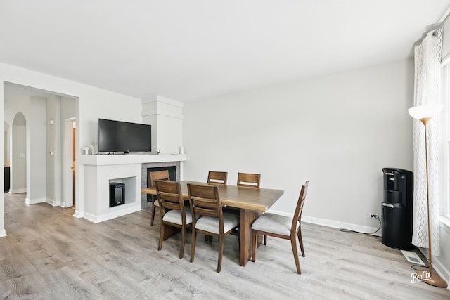 1272 Georgetown Way, Vernon Hills, IL 60061 - dining area with light wood-type flooring, a glass covered fireplace, and arched walkways