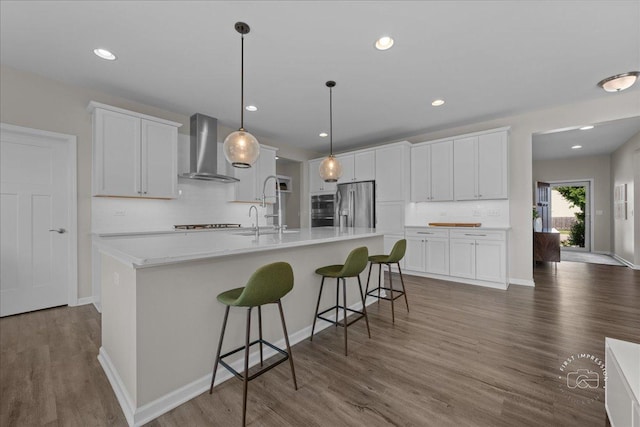 340 Hamilton Rd, Saint Charles, IL 60175 - kitchen featuring wall chimney exhaust hood, stainless steel fridge, decorative backsplash, dark wood-style flooring, and an island with sink