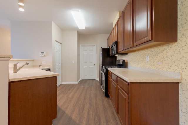 8126 Concord Ln Unit A, Justice, IL 60458 - kitchen featuring gas range, dark wood-style floors, light countertops, brown cabinets, and black microwave