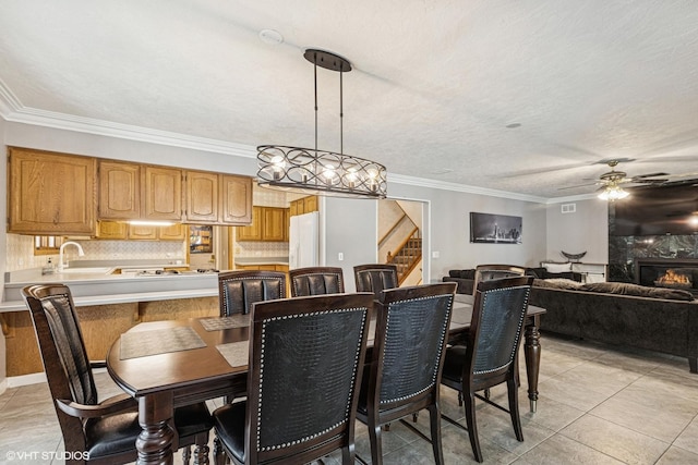2215 Yeoman St, Waukegan, IL 60087 - dining space with ceiling fan, stairs, crown molding, light tile patterned flooring, and a fireplace