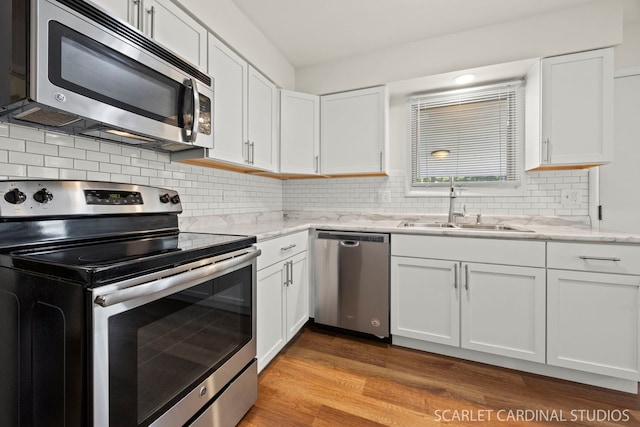 206-208 N Fremont St, Naperville, IL 60540 - kitchen with appliances with stainless steel finishes, white cabinets, light wood-type flooring, and light stone counters