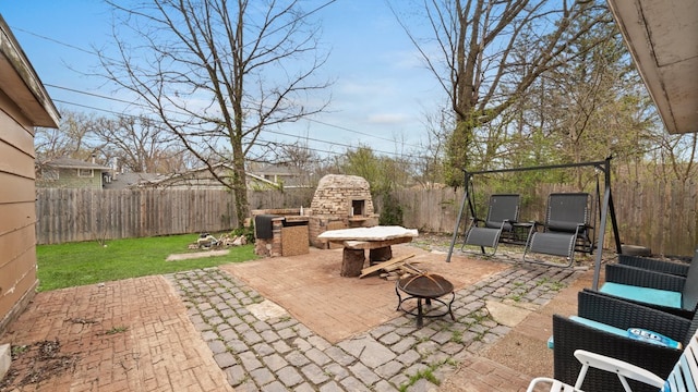 36 Monee Rd, Park Forest, IL 60466 - fenced backyard with an outdoor stone fireplace, a fire pit, and a patio